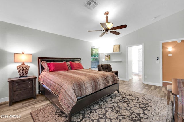 bedroom with light wood-type flooring, visible vents, baseboards, and vaulted ceiling