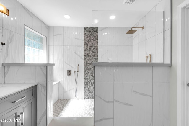 full bath with vanity, visible vents, recessed lighting, walk in shower, and tile walls