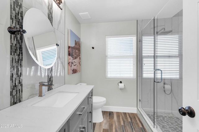 bathroom featuring a shower stall, wood finished floors, visible vents, and a wealth of natural light