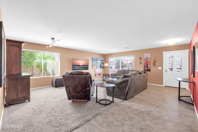 living area featuring baseboards, light carpet, and light tile patterned flooring