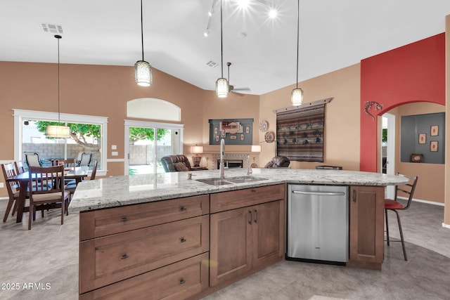 kitchen featuring visible vents, arched walkways, a sink, dishwasher, and open floor plan