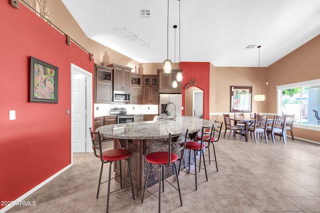 dining space featuring vaulted ceiling, baseboards, and visible vents