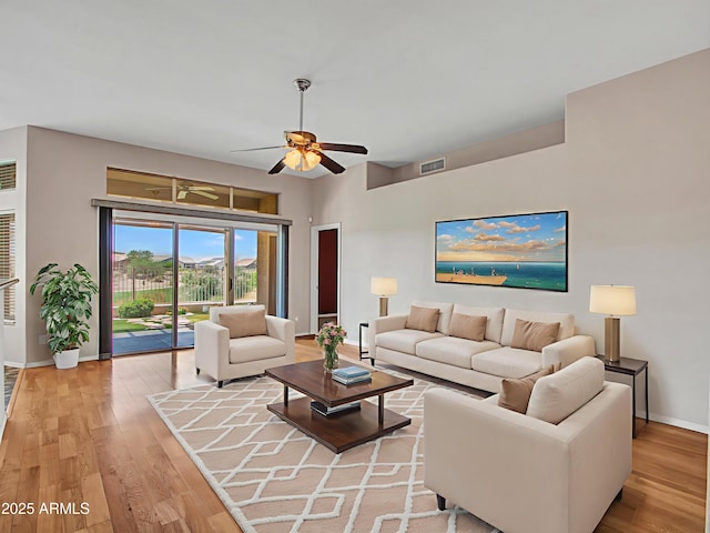 11547 W King Snake Ct, Surprise, AZ 85378 - living room with baseboards, light wood-style flooring, and a ceiling fan