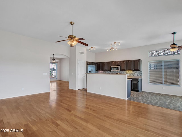 11547 W King Snake Ct, Surprise, AZ 85378 - unfurnished living room with ceiling fan, light wood-style flooring, and arched walkways