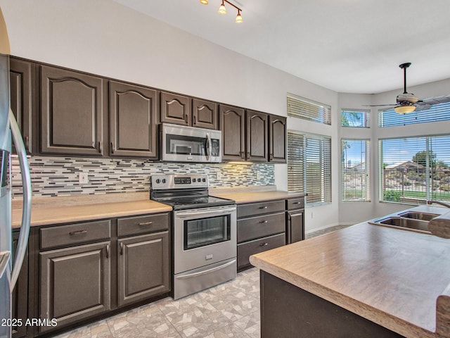 11547 W King Snake Ct, Surprise, AZ 85378 - kitchen featuring appliances with stainless steel finishes, backsplash, a ceiling fan, a sink, and dark brown cabinets
