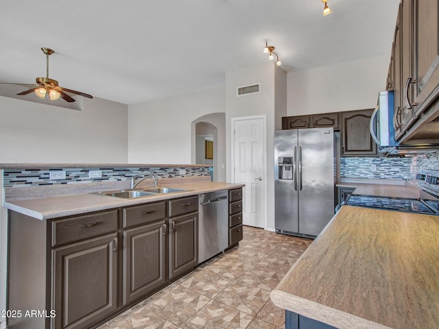 11547 W King Snake Ct, Surprise, AZ 85378 - kitchen featuring appliances with stainless steel finishes, a sink, arched walkways, and backsplash