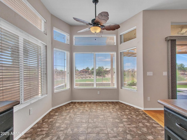 11547 W King Snake Ct, Surprise, AZ 85378 - unfurnished dining area with plenty of natural light, a ceiling fan, and stone finish flooring