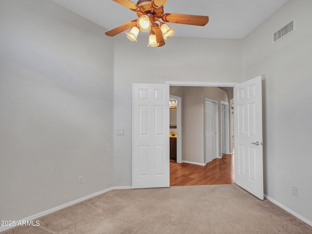 11547 W King Snake Ct, Surprise, AZ 85378 - unfurnished bedroom with light colored carpet, baseboards, and a ceiling fan