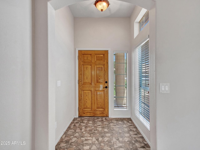 11547 W King Snake Ct, Surprise, AZ 85378 - foyer featuring healthy amount of natural light, baseboards, arched walkways, and stone finish floors