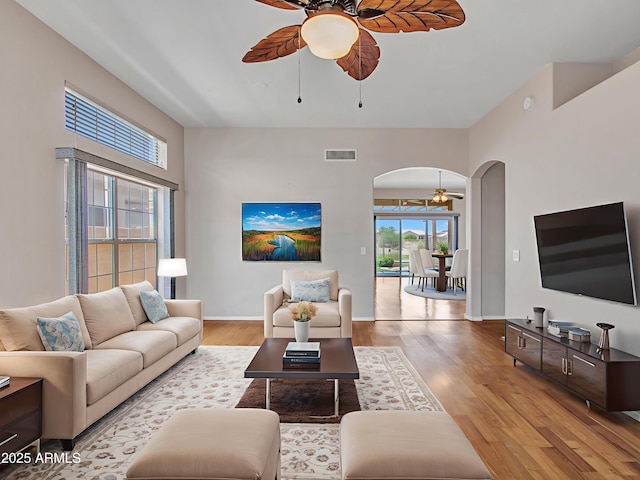 11547 W King Snake Ct, Surprise, AZ 85378 - living room with ceiling fan, arched walkways, wood finished floors, and baseboards