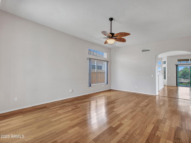 11547 W King Snake Ct, Surprise, AZ 85378 - unfurnished room featuring arched walkways, light wood-style floors, ceiling fan, and baseboards