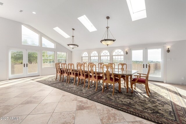 tiled dining room with a skylight, high vaulted ceiling, and french doors