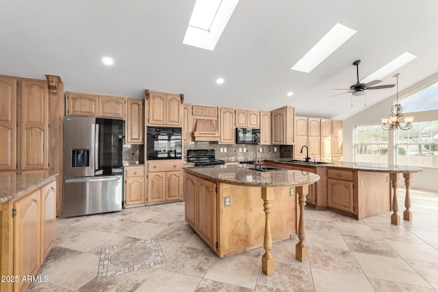 kitchen featuring a kitchen bar, sink, stone countertops, a center island, and black appliances