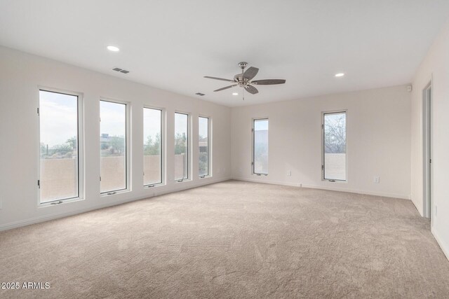 spare room with ceiling fan and light colored carpet