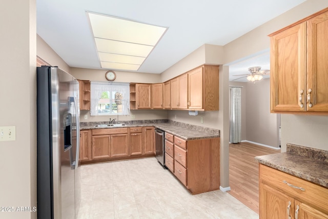 kitchen featuring stainless steel appliances, a sink, a ceiling fan, baseboards, and open shelves