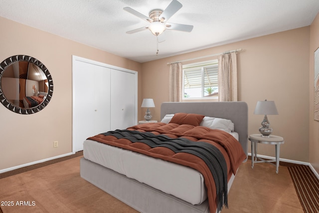 carpeted bedroom featuring ceiling fan, a closet, a textured ceiling, and baseboards