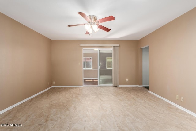 unfurnished room with a ceiling fan and baseboards