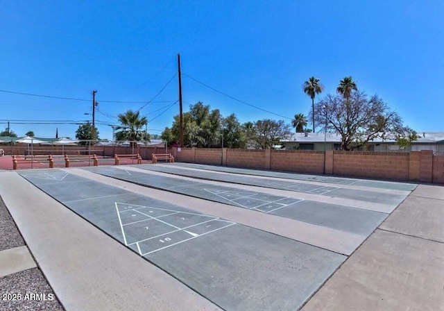 view of home's community featuring fence and shuffleboard