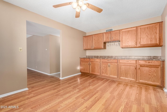 kitchen with light wood-style floors, visible vents, and baseboards