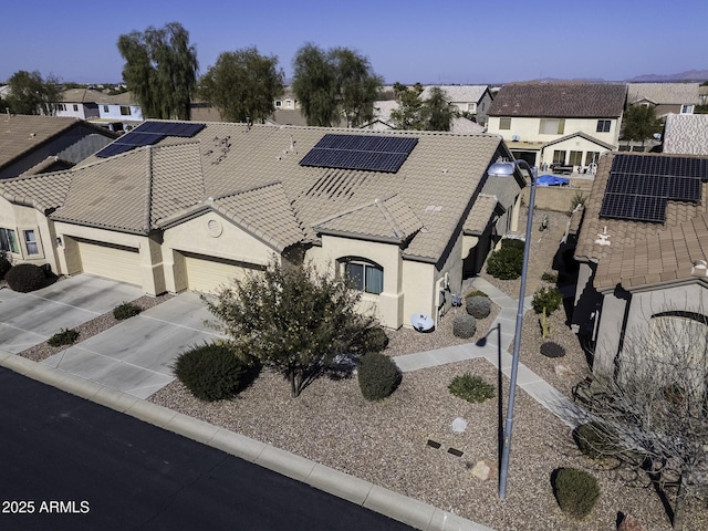 view of front facade with a garage and solar panels