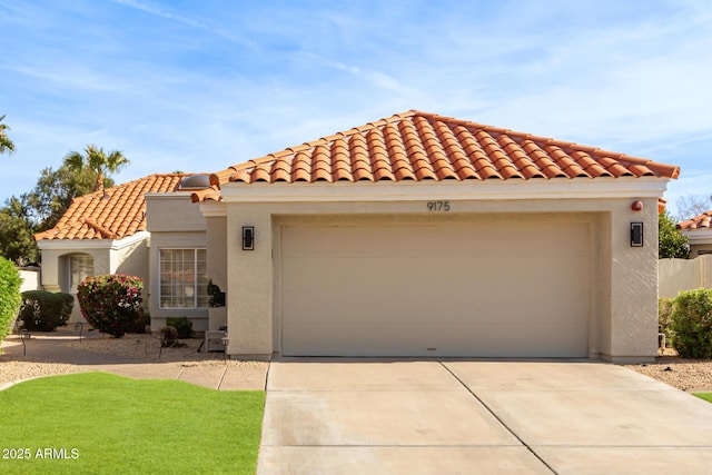 mediterranean / spanish home with an attached garage, a tiled roof, concrete driveway, and stucco siding