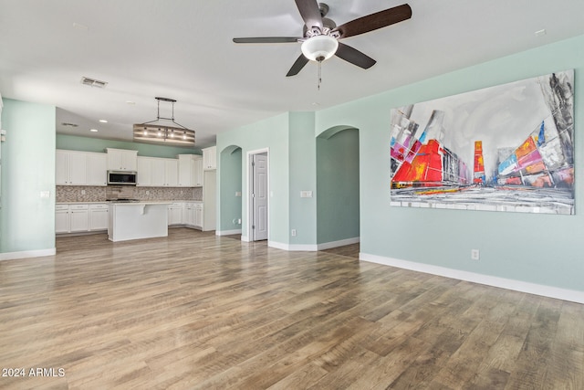 unfurnished living room featuring light hardwood / wood-style floors and ceiling fan