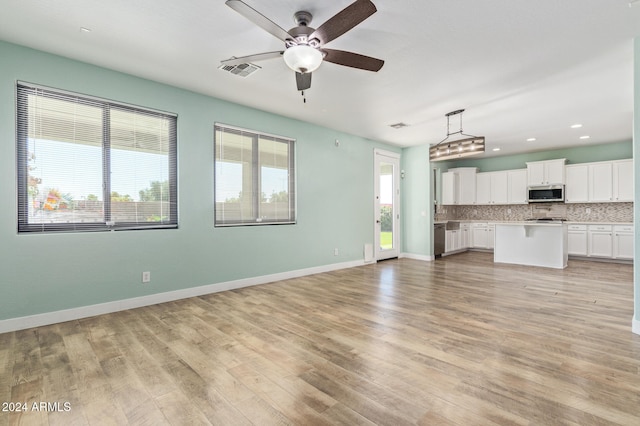 unfurnished living room with light hardwood / wood-style floors and ceiling fan