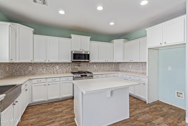 kitchen with white cabinetry, appliances with stainless steel finishes, and dark hardwood / wood-style flooring