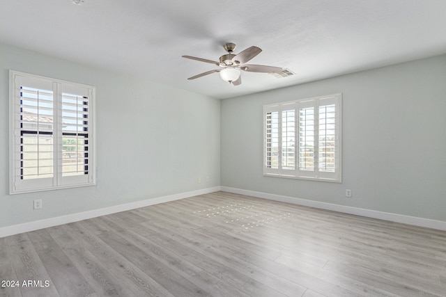 unfurnished room featuring a wealth of natural light, light wood-type flooring, and ceiling fan