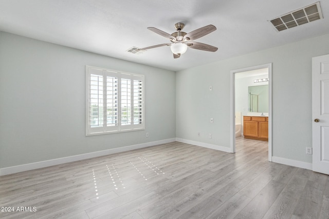 unfurnished bedroom featuring ensuite bathroom, light hardwood / wood-style flooring, and ceiling fan