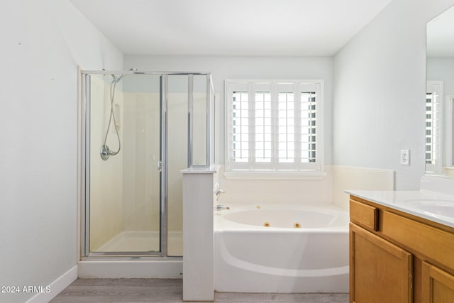 bathroom with vanity, a wealth of natural light, separate shower and tub, and hardwood / wood-style floors