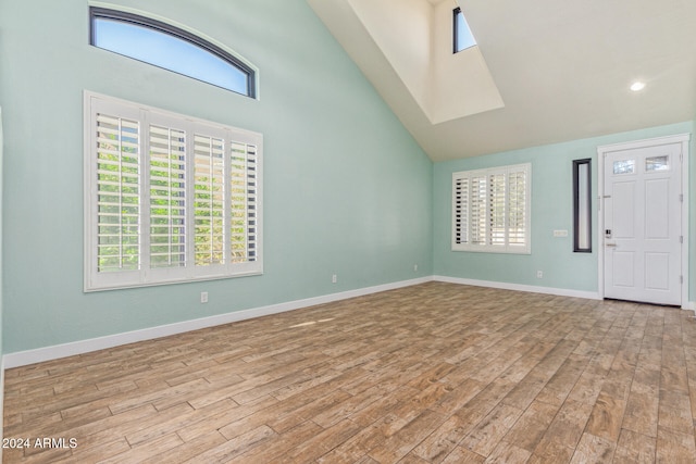 foyer entrance with high vaulted ceiling and light hardwood / wood-style flooring