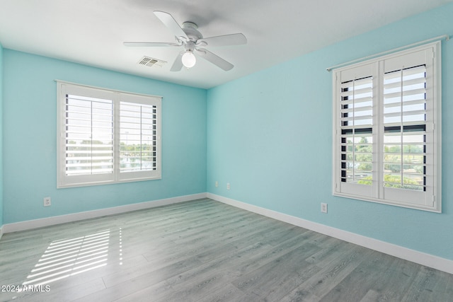 unfurnished room with light hardwood / wood-style floors, a healthy amount of sunlight, and ceiling fan