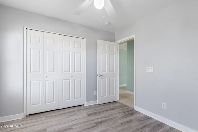 unfurnished bedroom with light hardwood / wood-style flooring, a closet, and ceiling fan