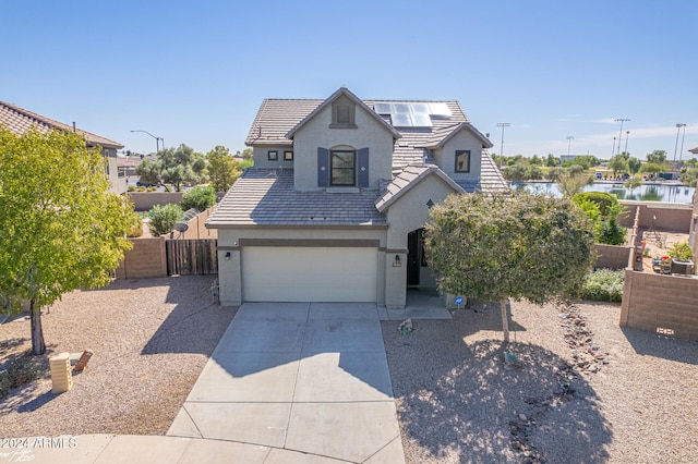 view of front of home with a garage and a water view