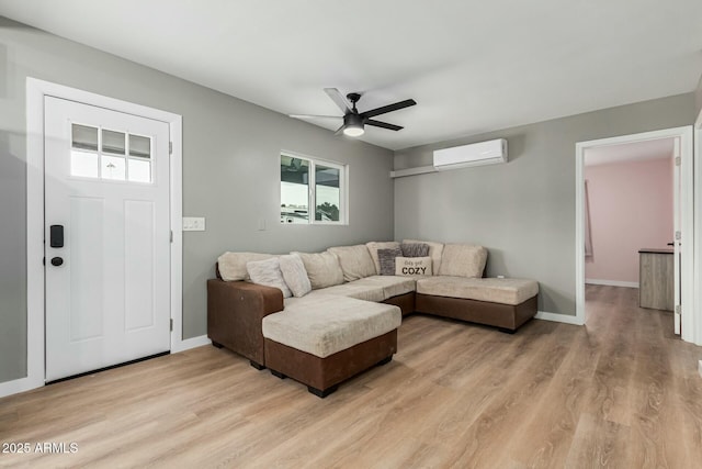 living room with light hardwood / wood-style flooring, ceiling fan, and a wall mounted AC