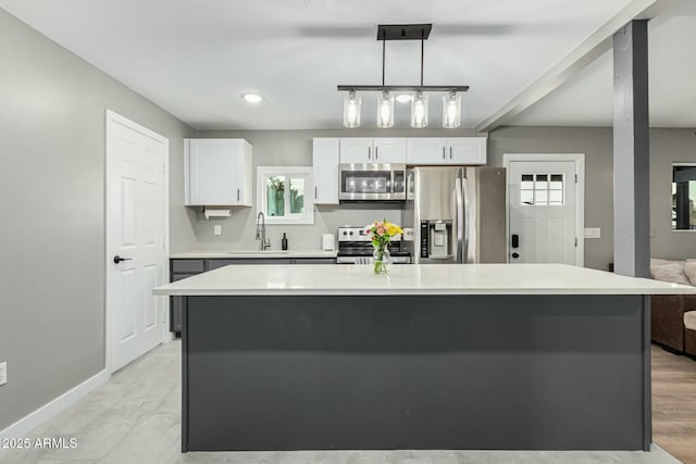 kitchen with sink, a center island, stainless steel appliances, white cabinets, and hanging light fixtures