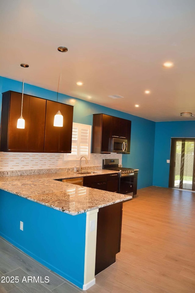 728 S Meadowood Ln, Sierra Vista, AZ 85635 - kitchen with stainless steel appliances, light stone counters, decorative backsplash, a sink, and light wood-style floors