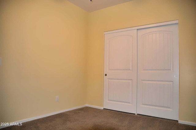 728 S Meadowood Ln, Sierra Vista, AZ 85635 - unfurnished bedroom featuring dark colored carpet, a closet, and baseboards