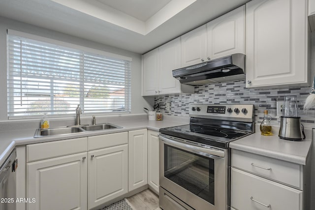 kitchen with tasteful backsplash, sink, white cabinets, and appliances with stainless steel finishes