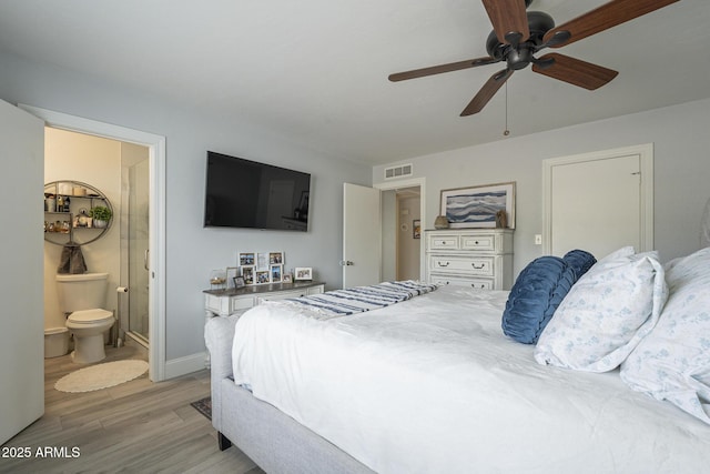 bedroom with ensuite bathroom, light wood-type flooring, and ceiling fan