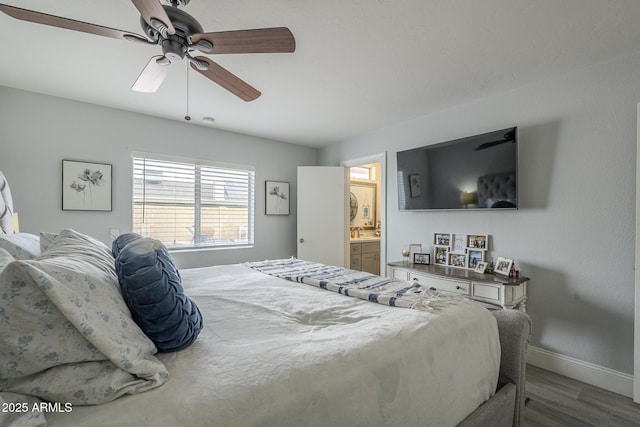 bedroom featuring hardwood / wood-style flooring, connected bathroom, and ceiling fan