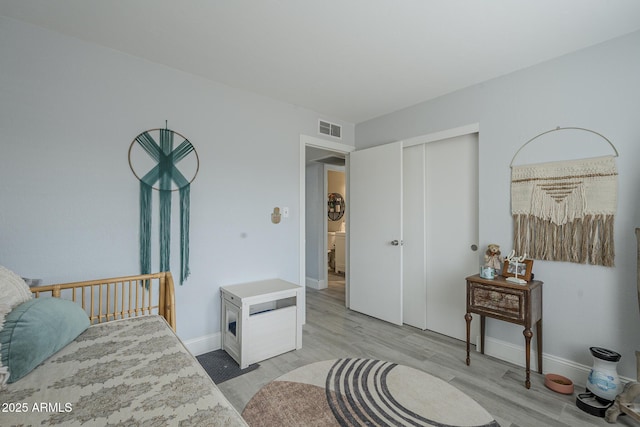 bedroom with a closet and light hardwood / wood-style flooring