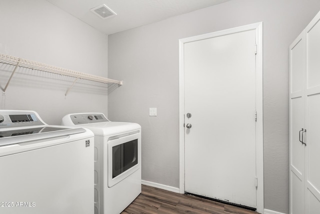 clothes washing area featuring laundry area, baseboards, visible vents, washer and clothes dryer, and dark wood finished floors