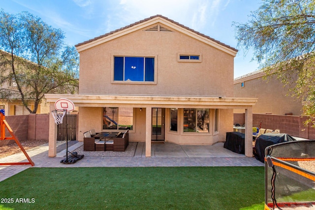 back of property with a yard, a fenced backyard, a patio, and stucco siding