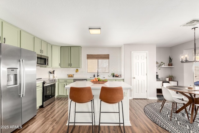 kitchen featuring a chandelier, light countertops, appliances with stainless steel finishes, and green cabinetry