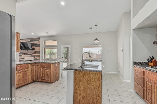 1207 E Clearview Dr, Casa Grande, AZ 85122 - kitchen with decorative backsplash, brown cabinetry, appliances with stainless steel finishes, a sink, and light tile patterned floors