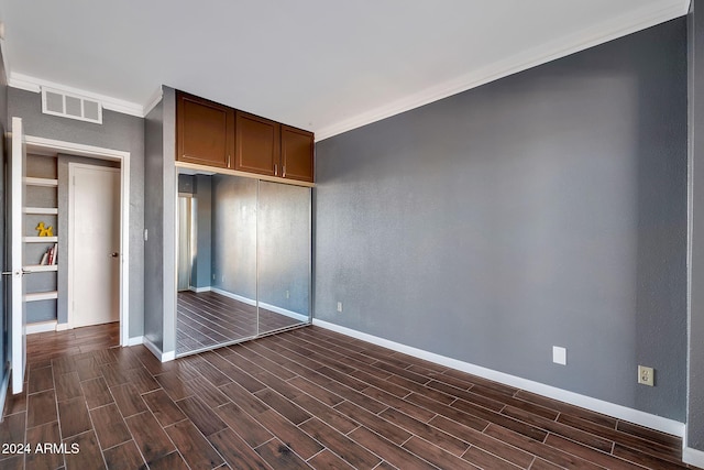 unfurnished bedroom with a closet and crown molding