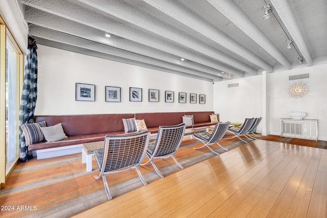 living room featuring hardwood / wood-style floors, rail lighting, and a textured ceiling