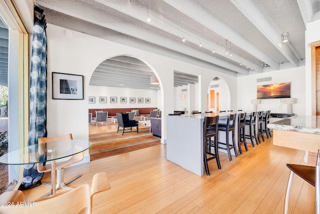 kitchen featuring a textured ceiling, light hardwood / wood-style flooring, and a breakfast bar area